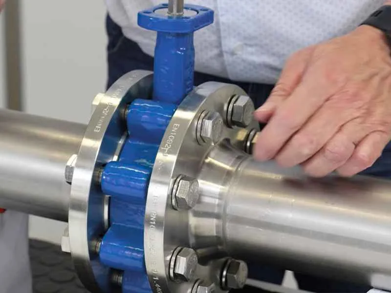A technician easily handling a butterfly valve for installation.